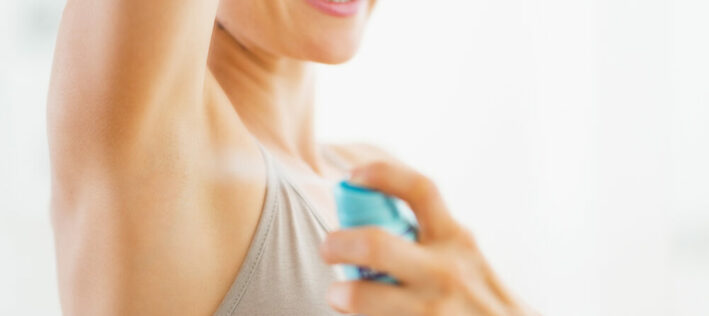 Woman spraying deodorant to her underarm Woman spraying deodorant to her underarm